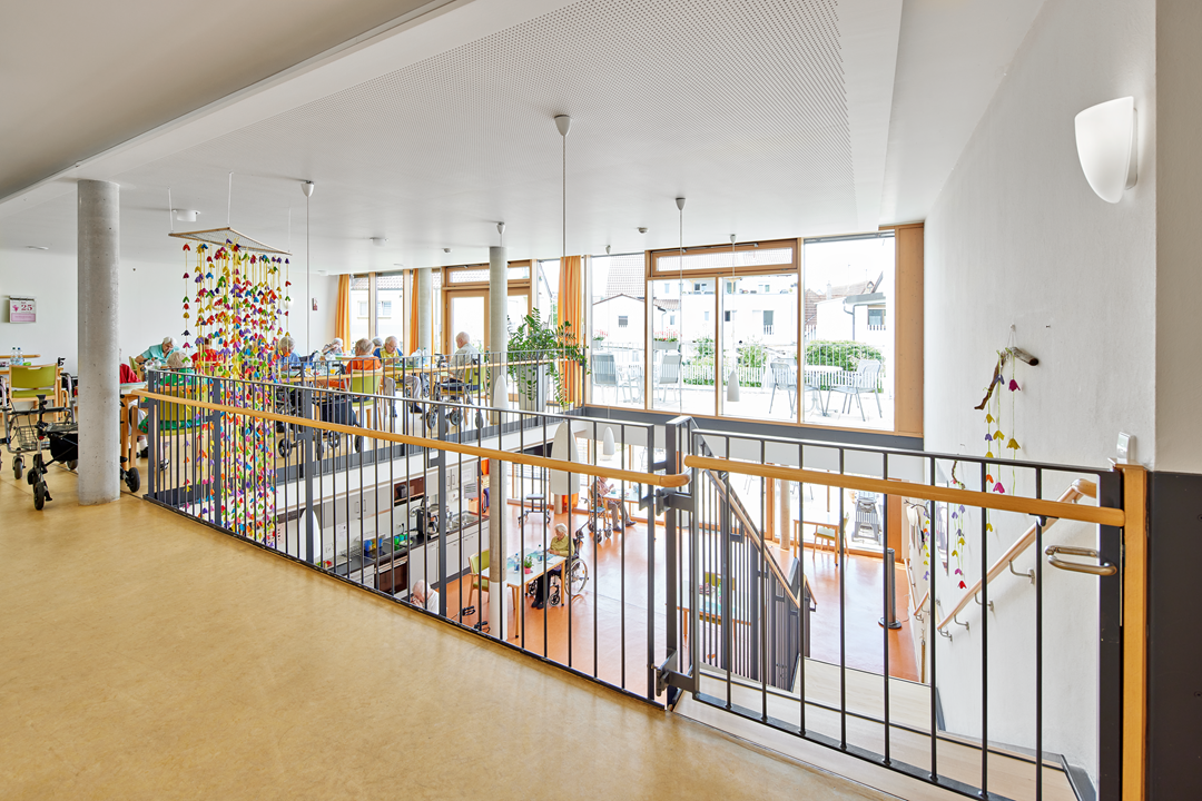 Heller Gemeinschaftsraum mit Dekoration und Tischgruppen.