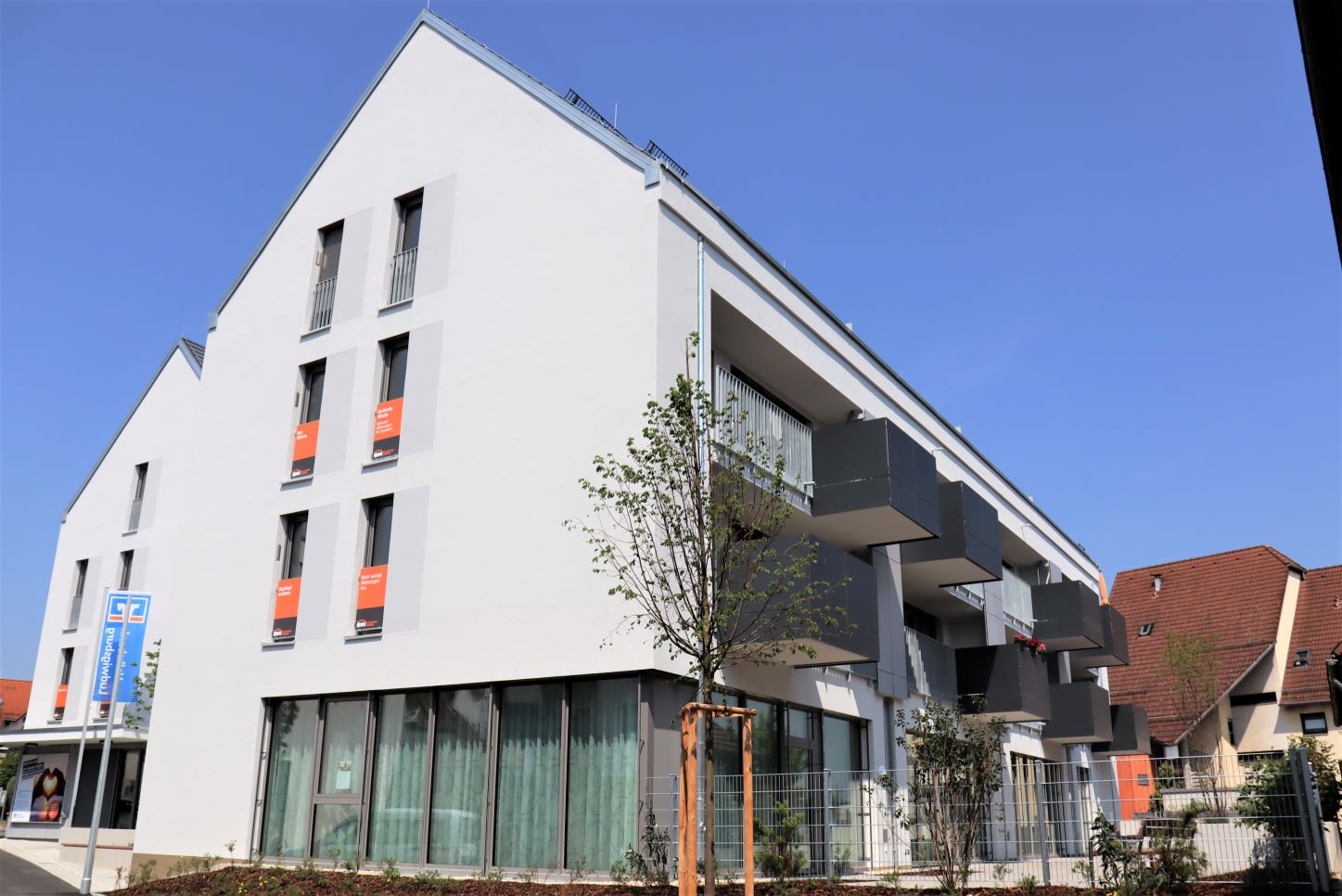 Modernes Wohngebäude mit Balkonen bei Sonnenschein.