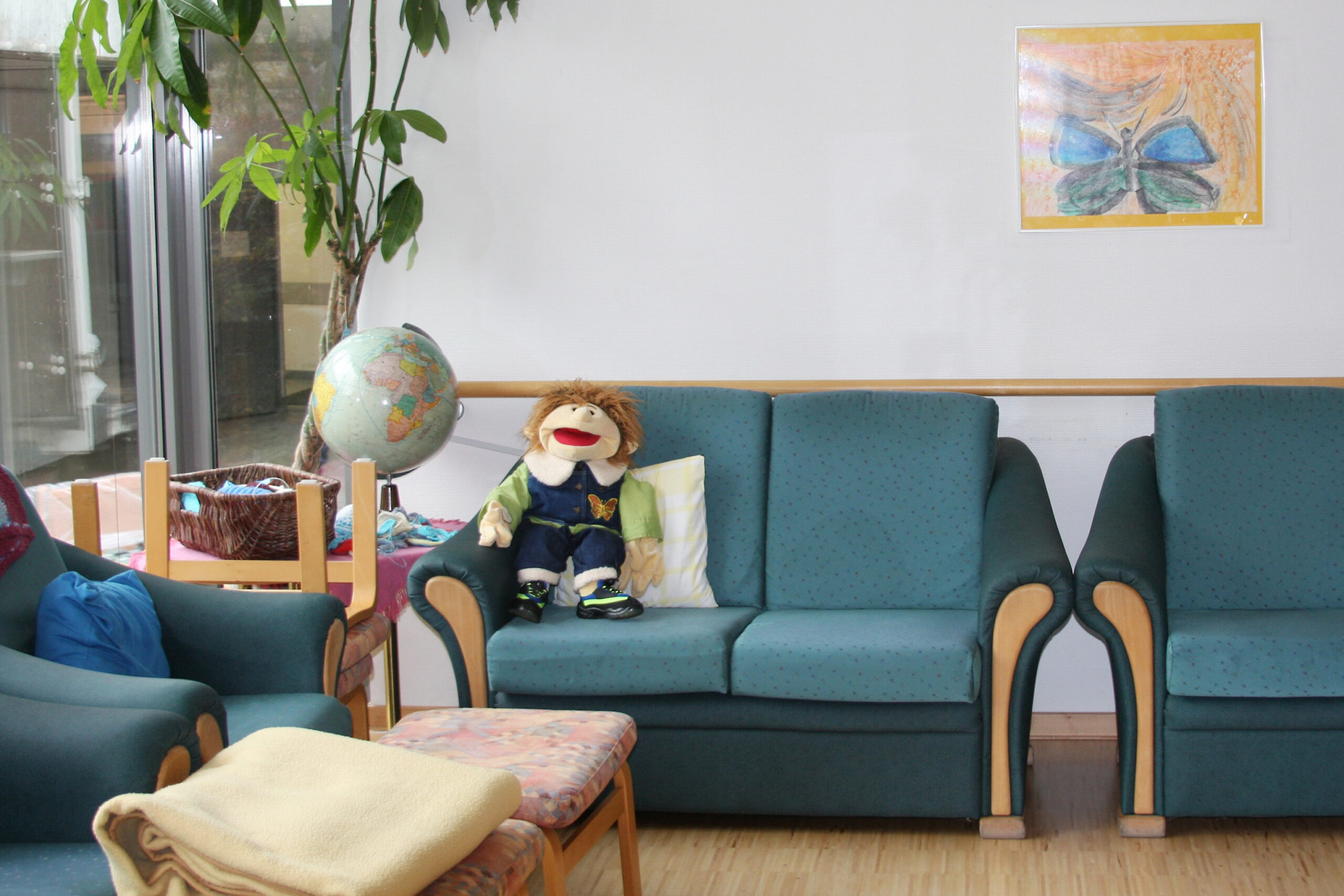 Gemütlicher Raum mit Puppenspielzeug und Globus.